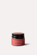 Pink lip balm container with black cap on a white background
