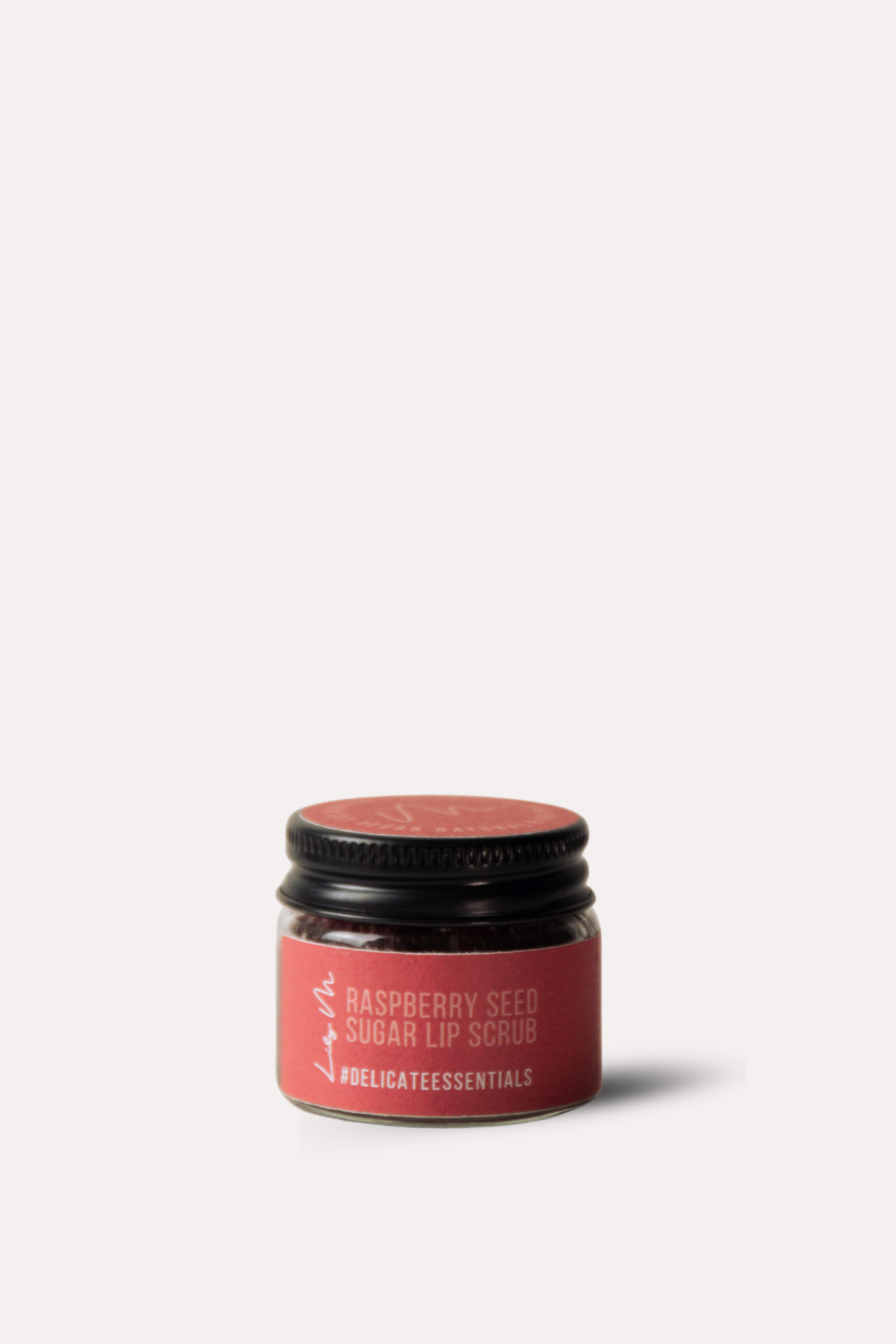 Pink lip balm container with black cap on a white background