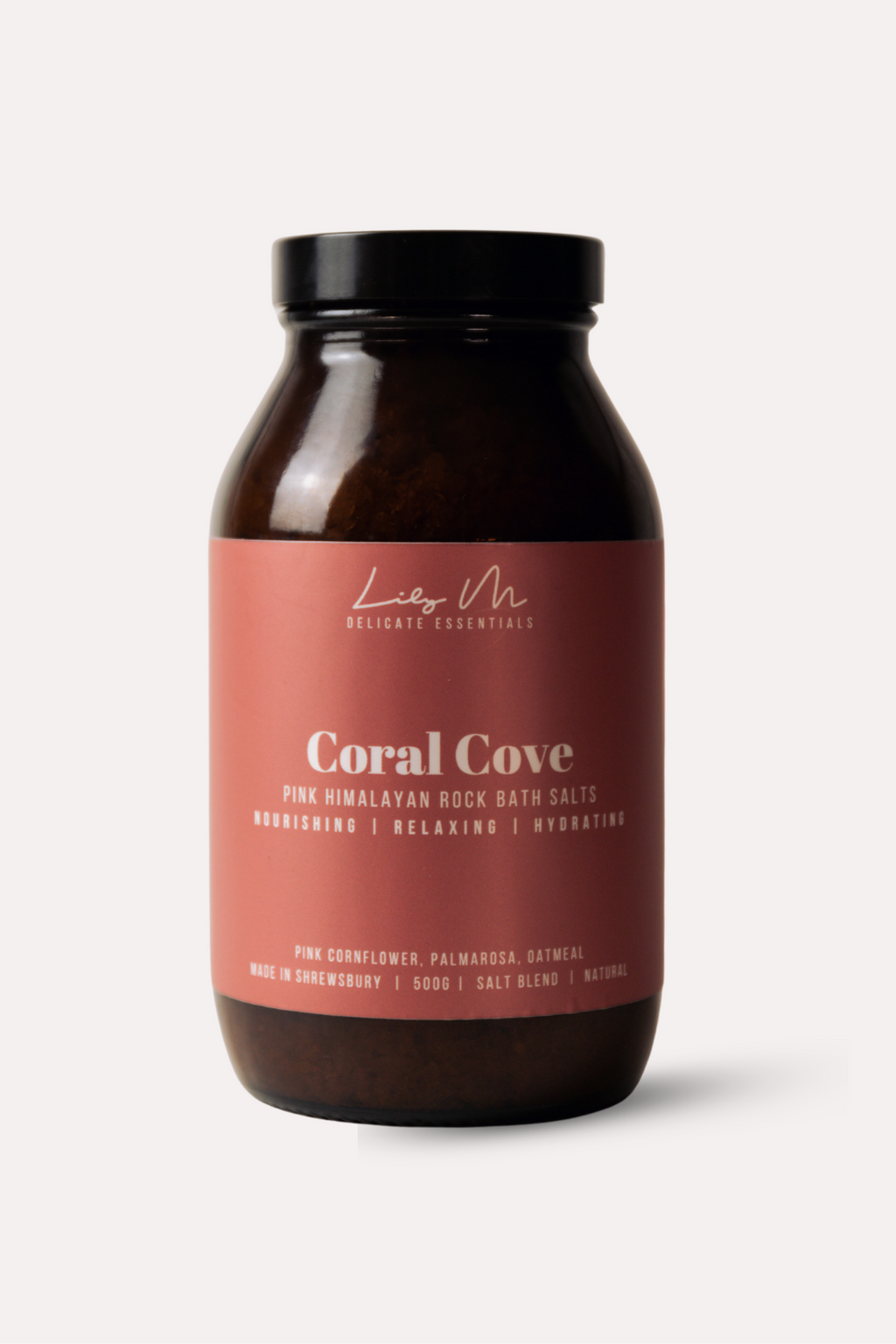 Bottle of Coral Cove bath salts with a pink label on a white background