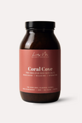Bottle of Coral Cove bath salts with a pink label on a white background