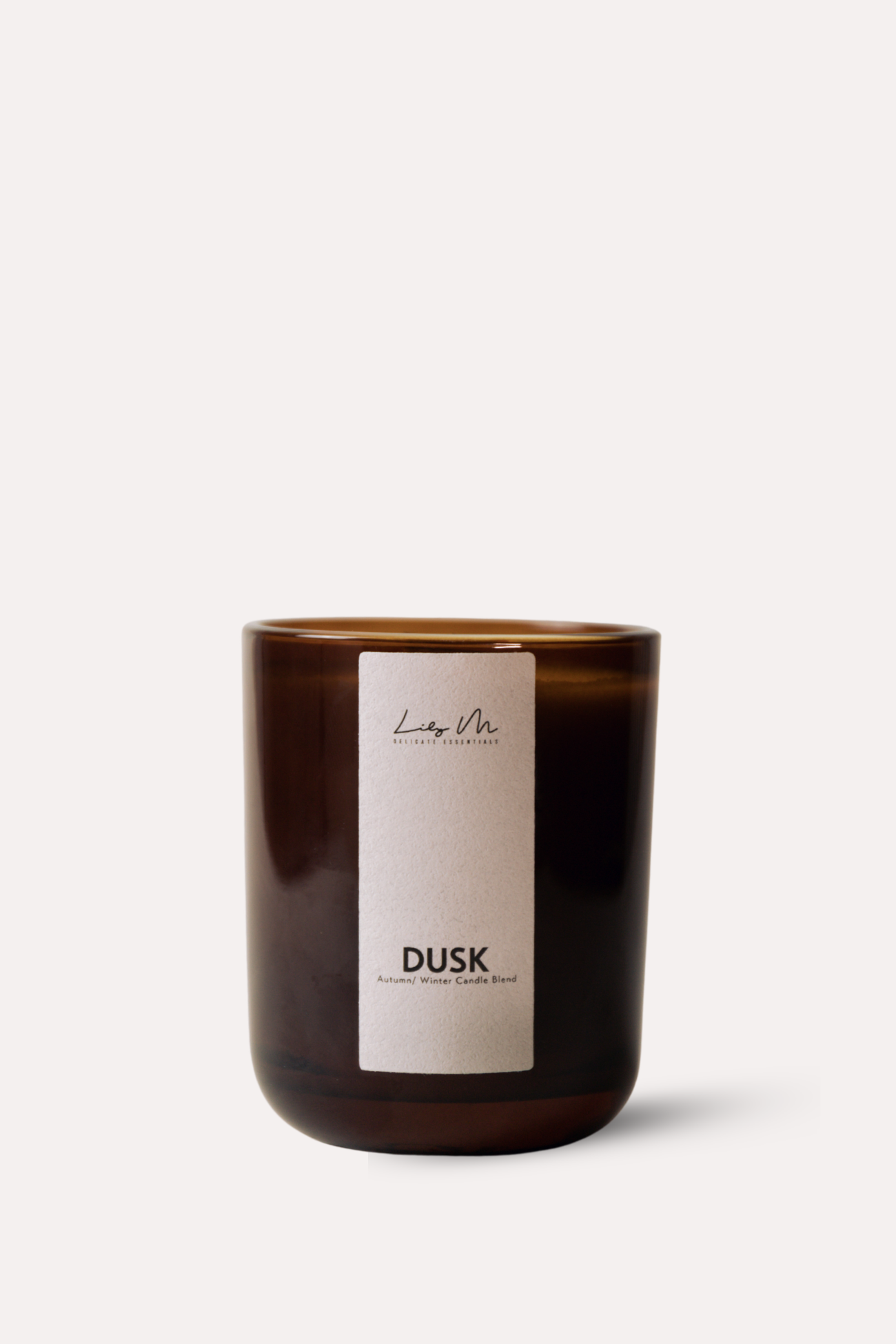 Brown candle with a white label on a light beige background