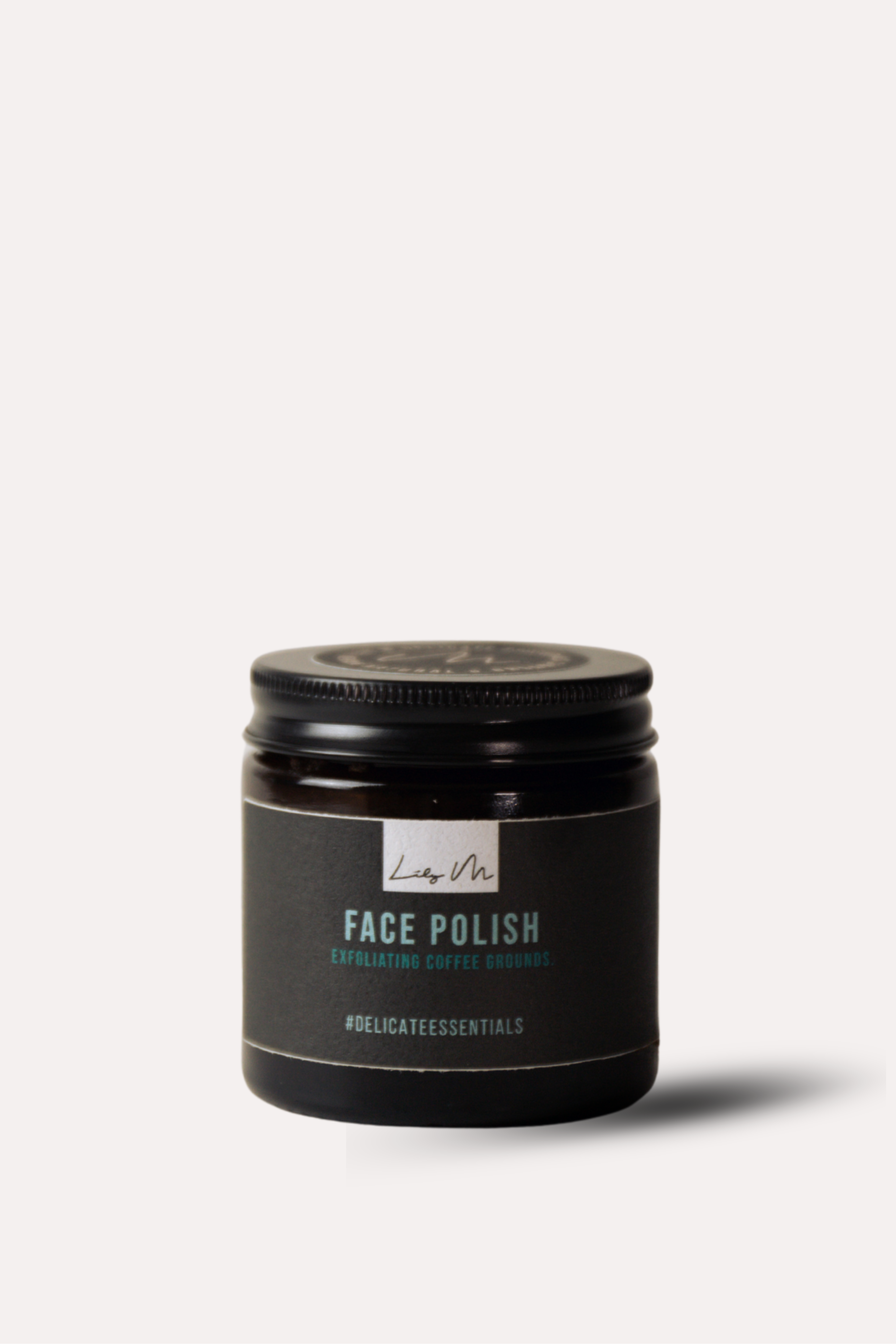 Jar of face polish with a black lid on a white background