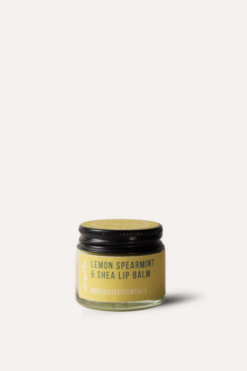 Jar of lemon spearmint and shea lip balm on a white background