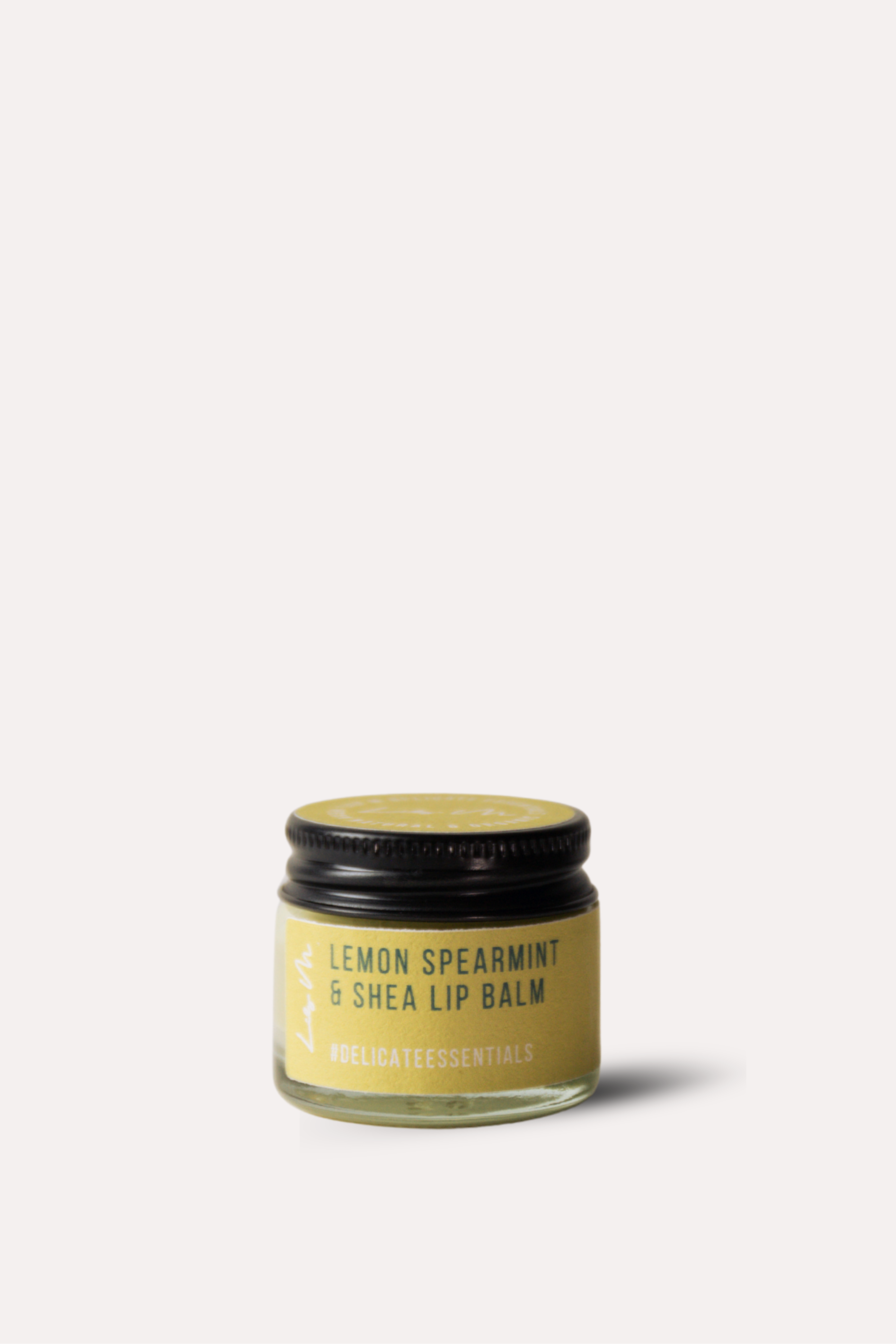 Jar of lemon spearmint and shea lip balm on a white background