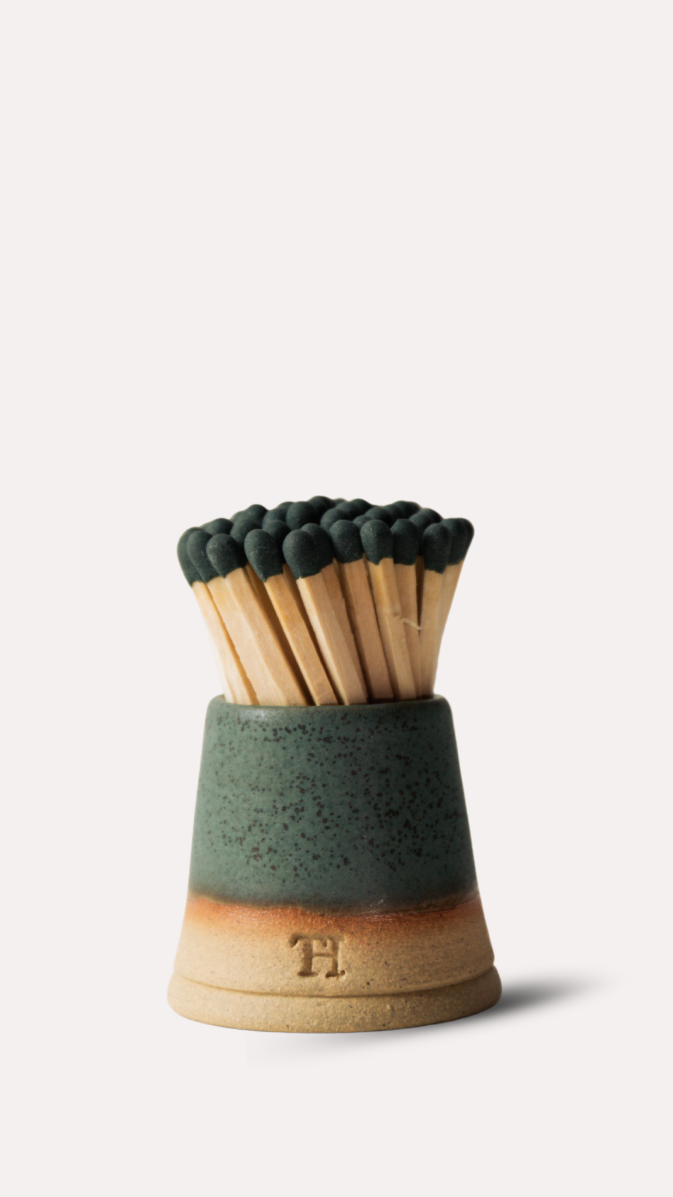 Matches in a ceramic holder with a logo on a white background