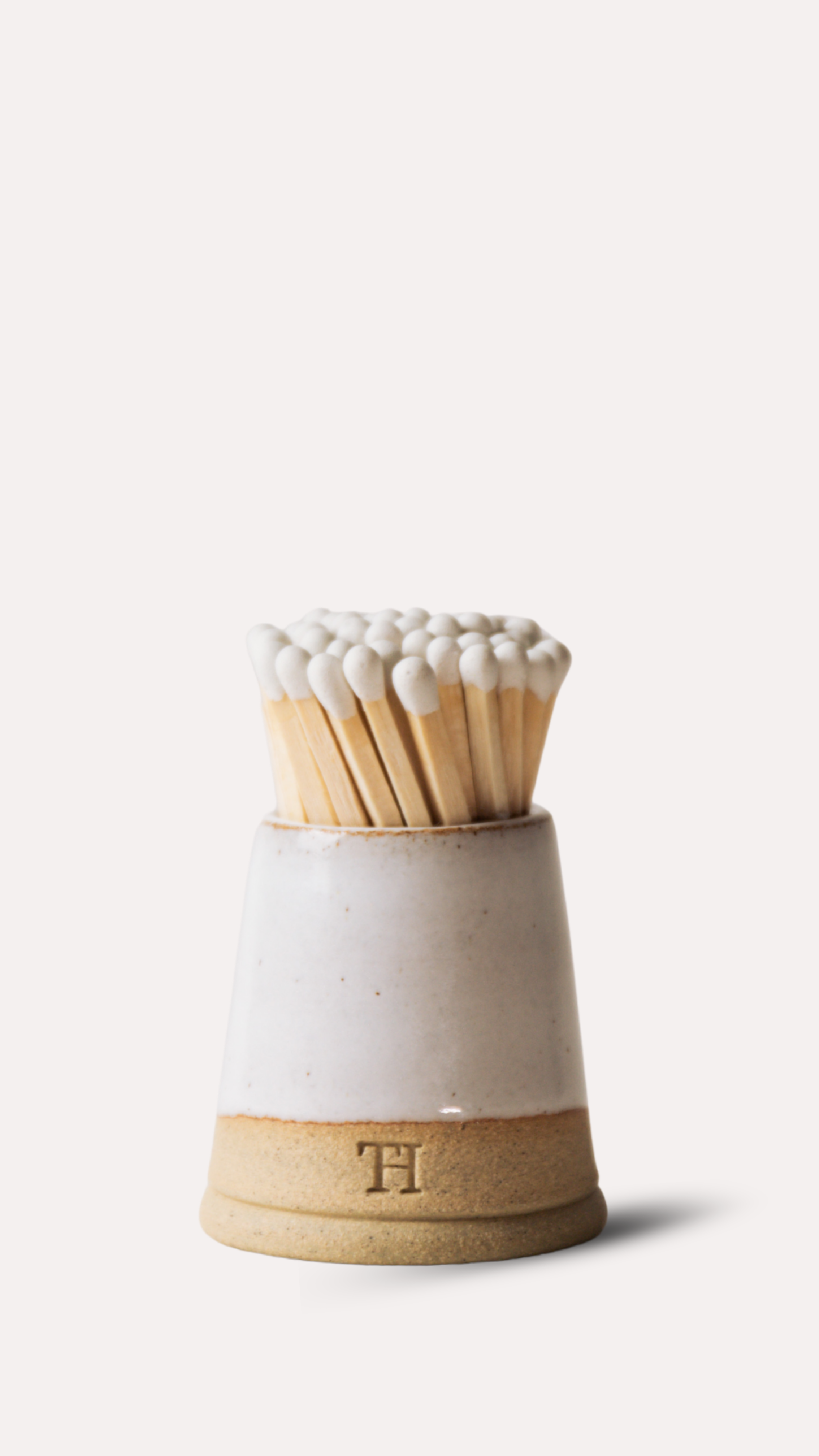 Matches in a ceramic holder on a white background