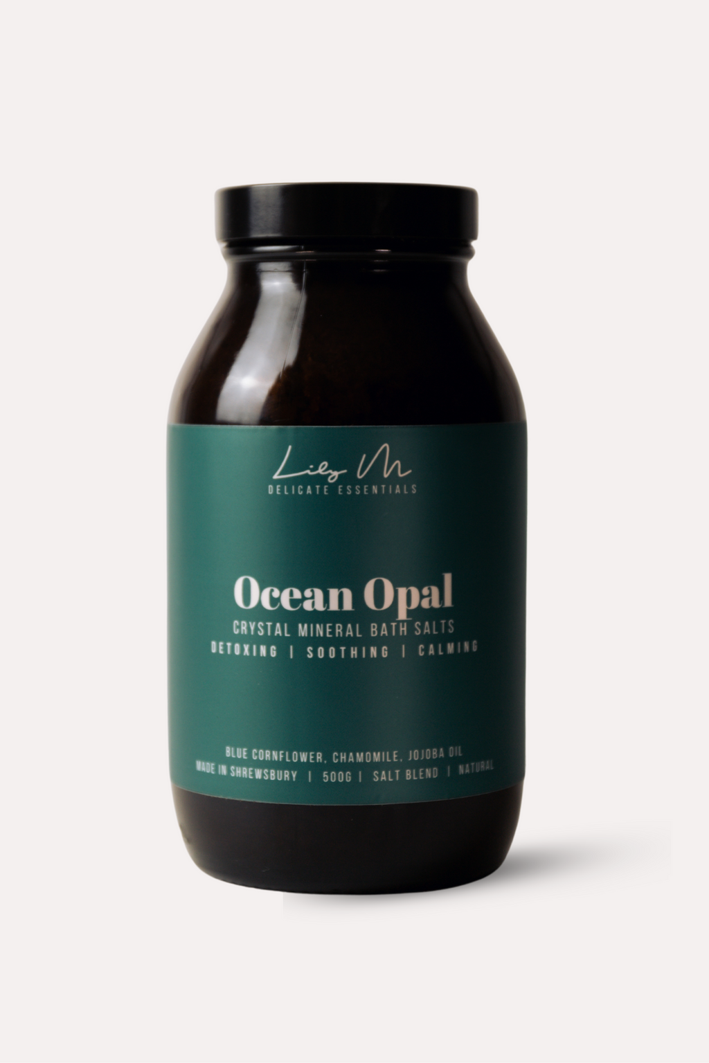 Bottle of Ocean Opal bath salts with a black lid on a white background