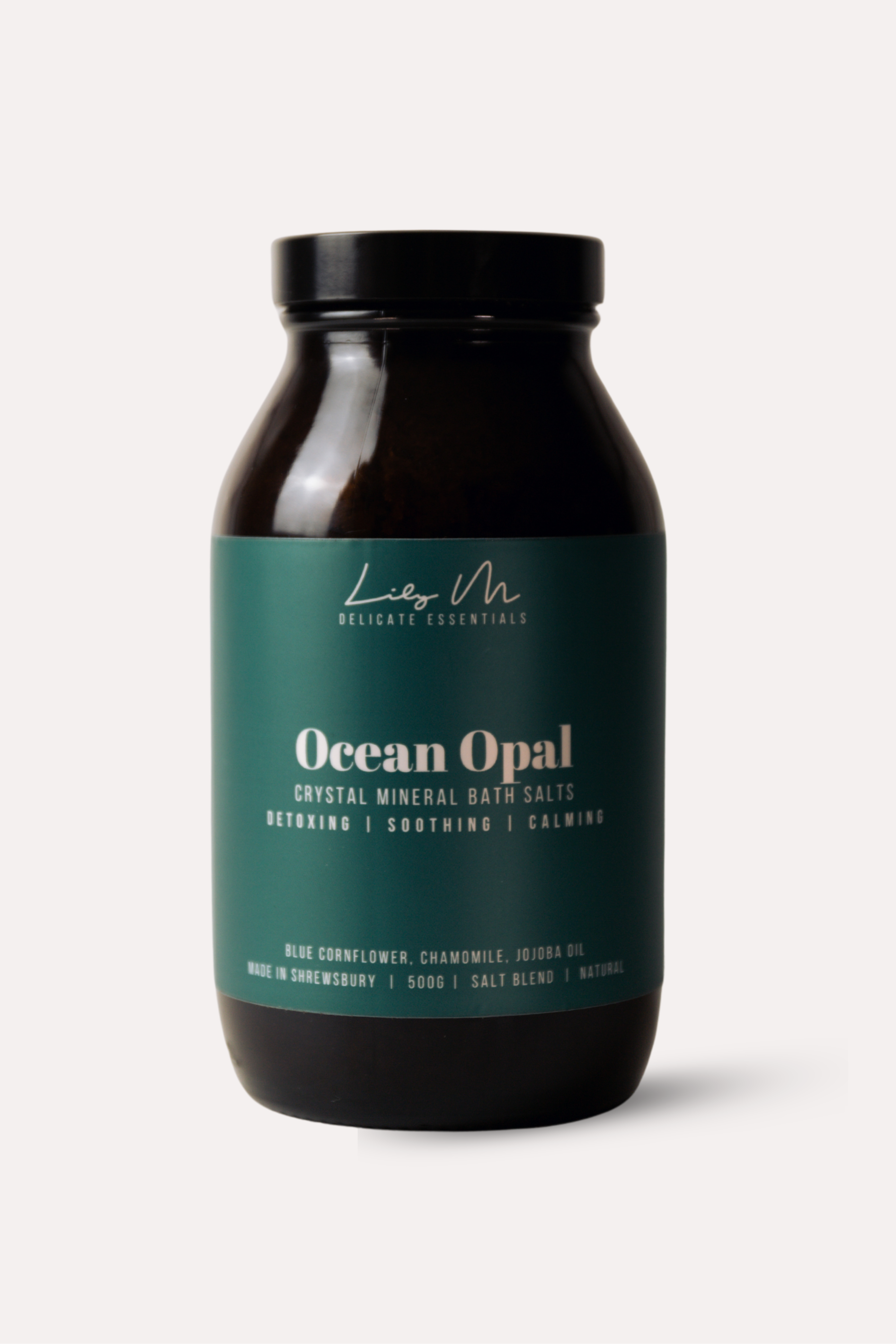 Bottle of Ocean Opal bath salts with a black lid on a white background