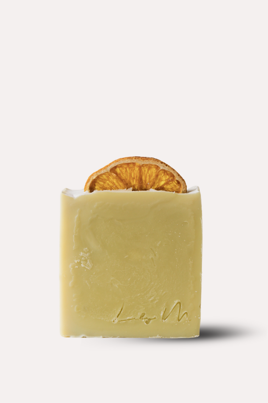 Bar of soap with a slice of orange inside on a white background