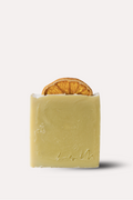 Bar of soap with a slice of orange inside on a white background