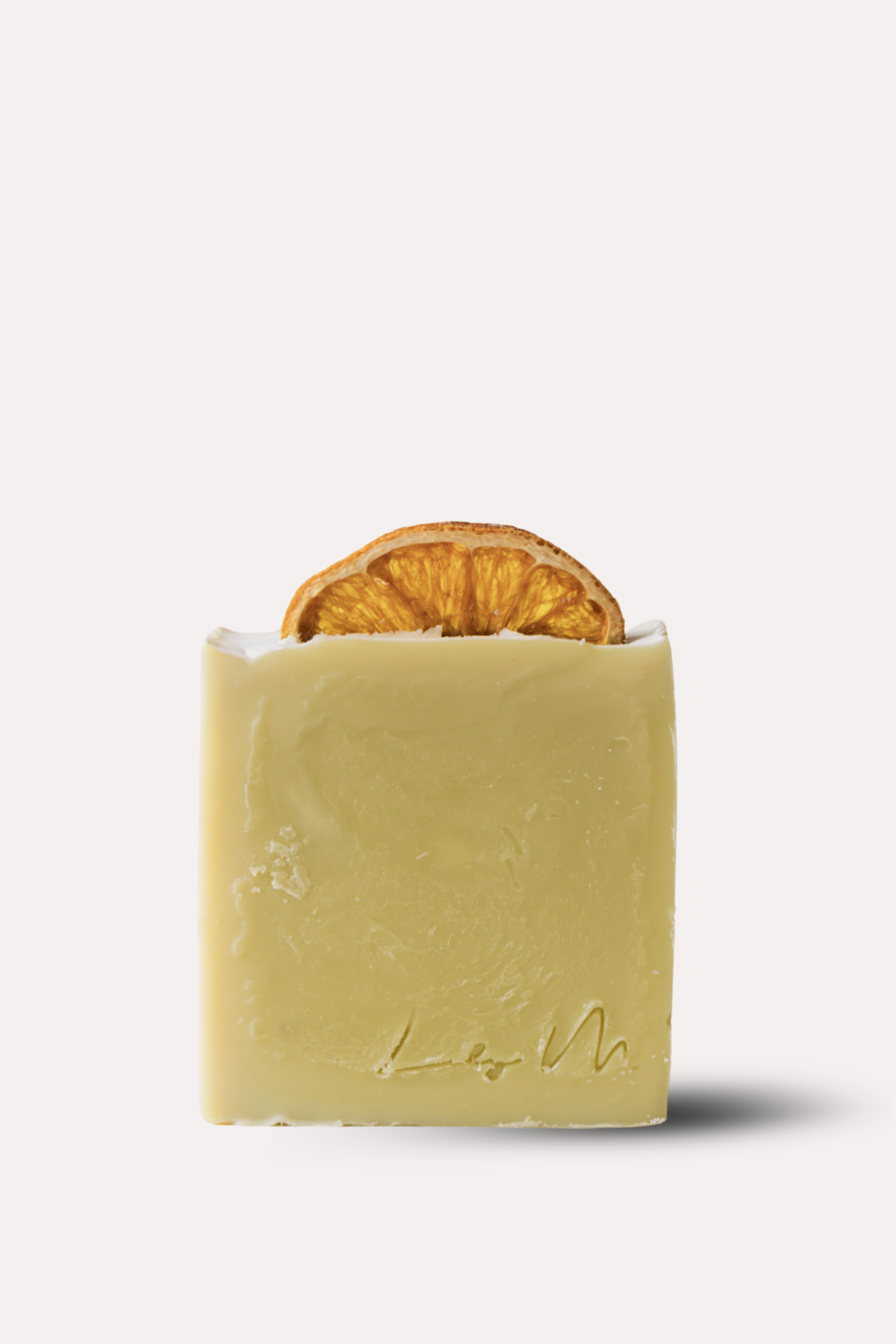 Bar of soap with a slice of orange inside on a white background