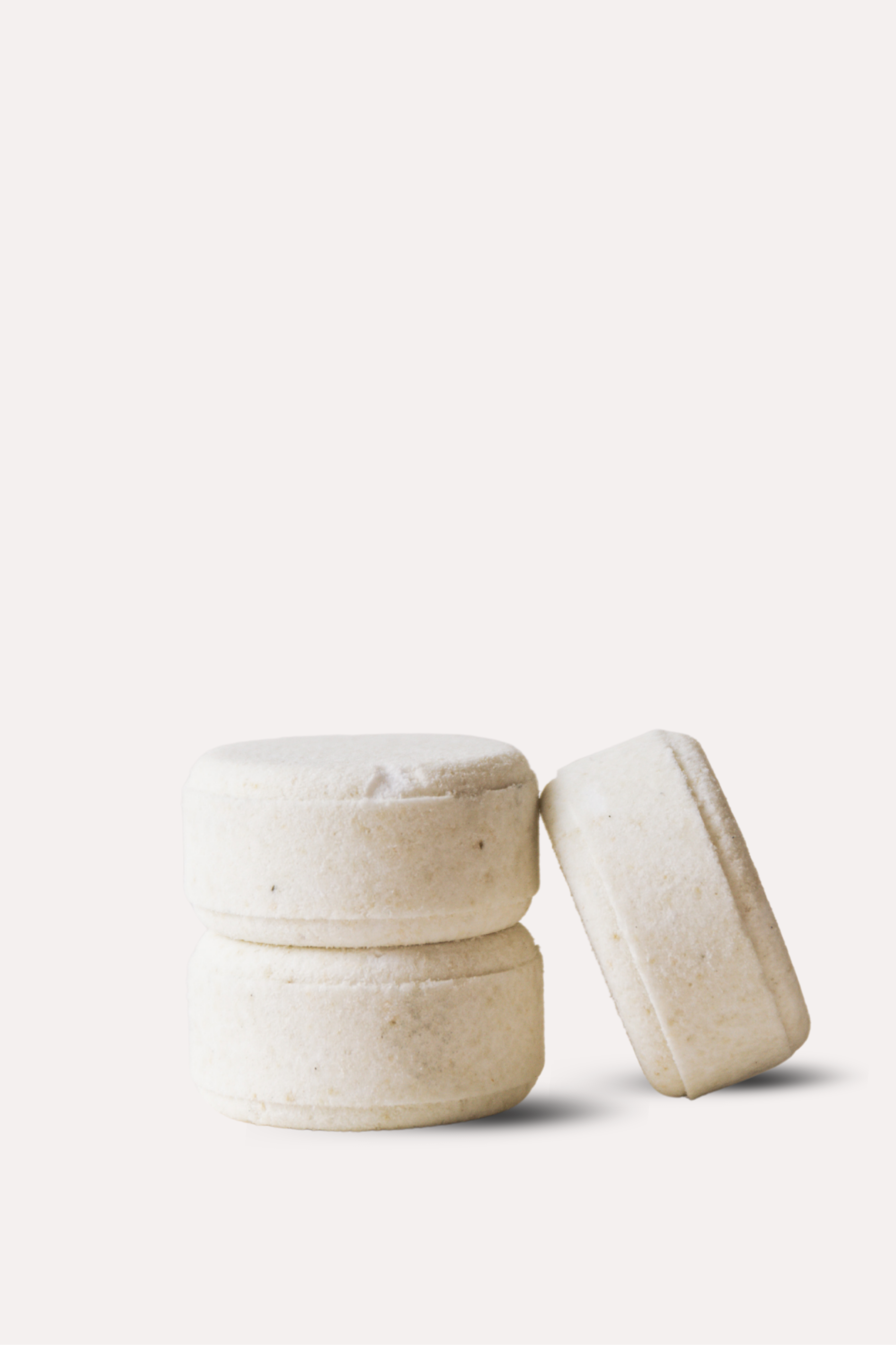 Three beige ceramic containers on a white background