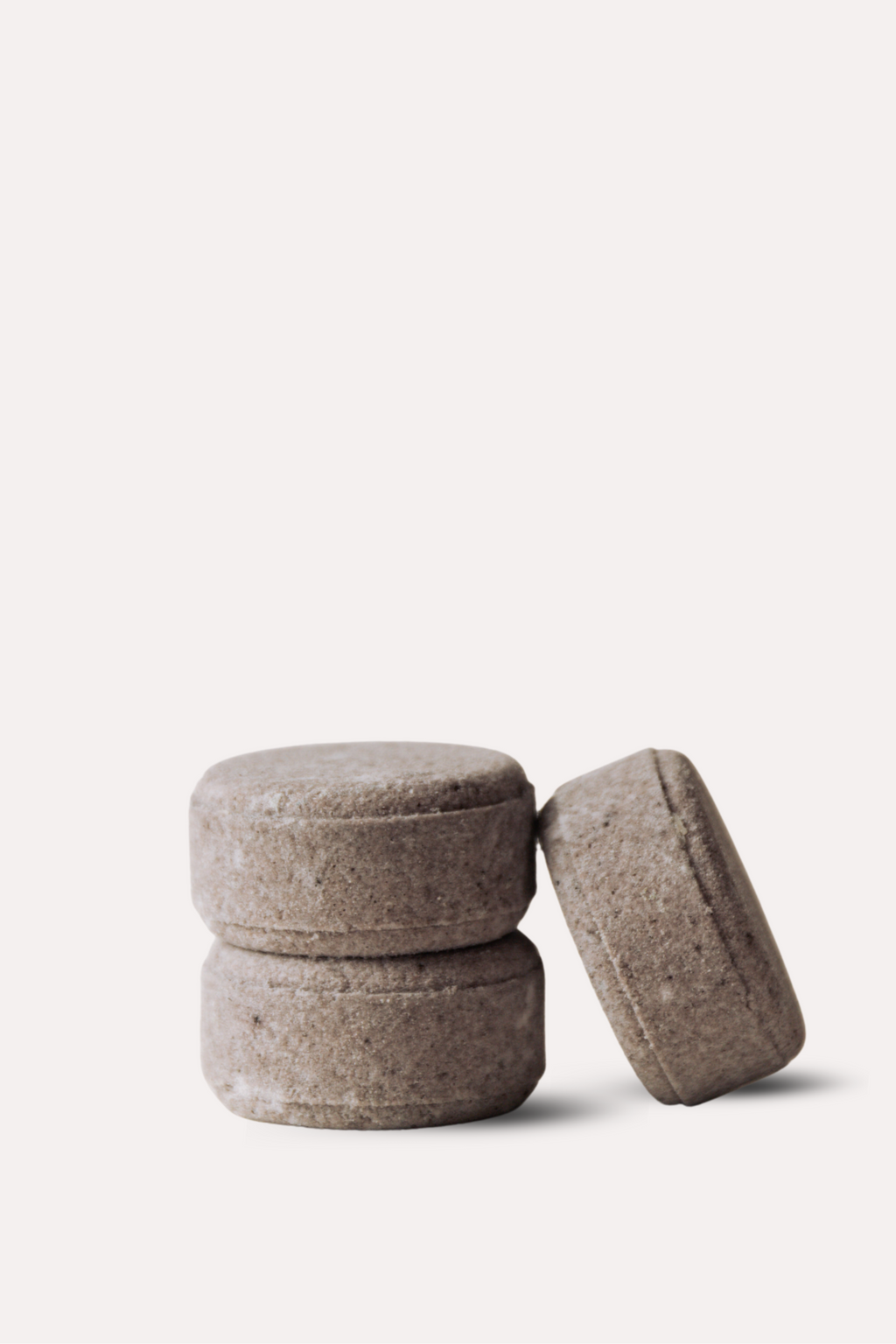 Three brown stone-like objects stacked on a white background