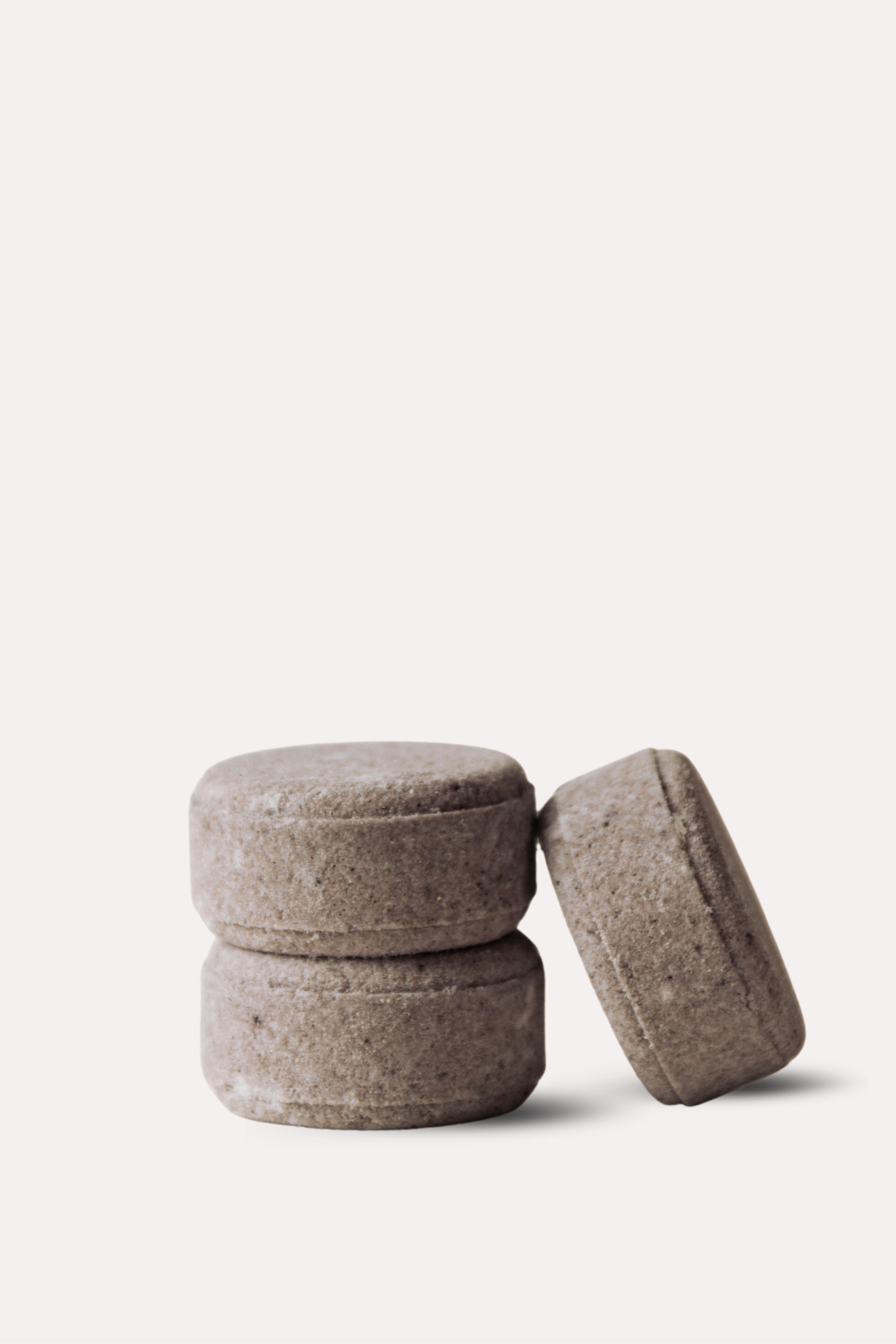 Three brown stone-like objects stacked on a white background