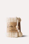 White woven soap bag with a label on a light beige background