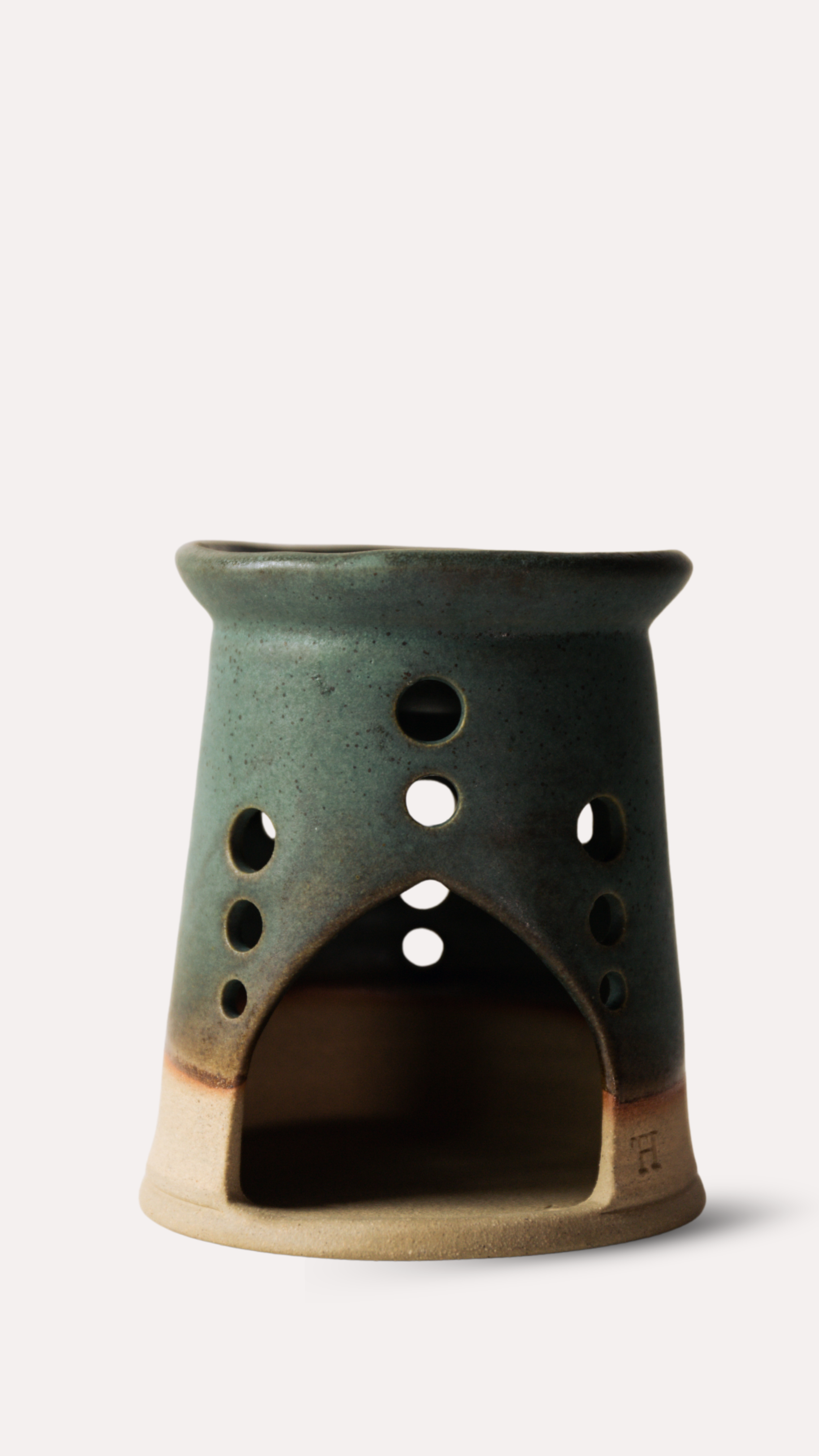 Green ceramic oil or wax melt burner with holes on a white background