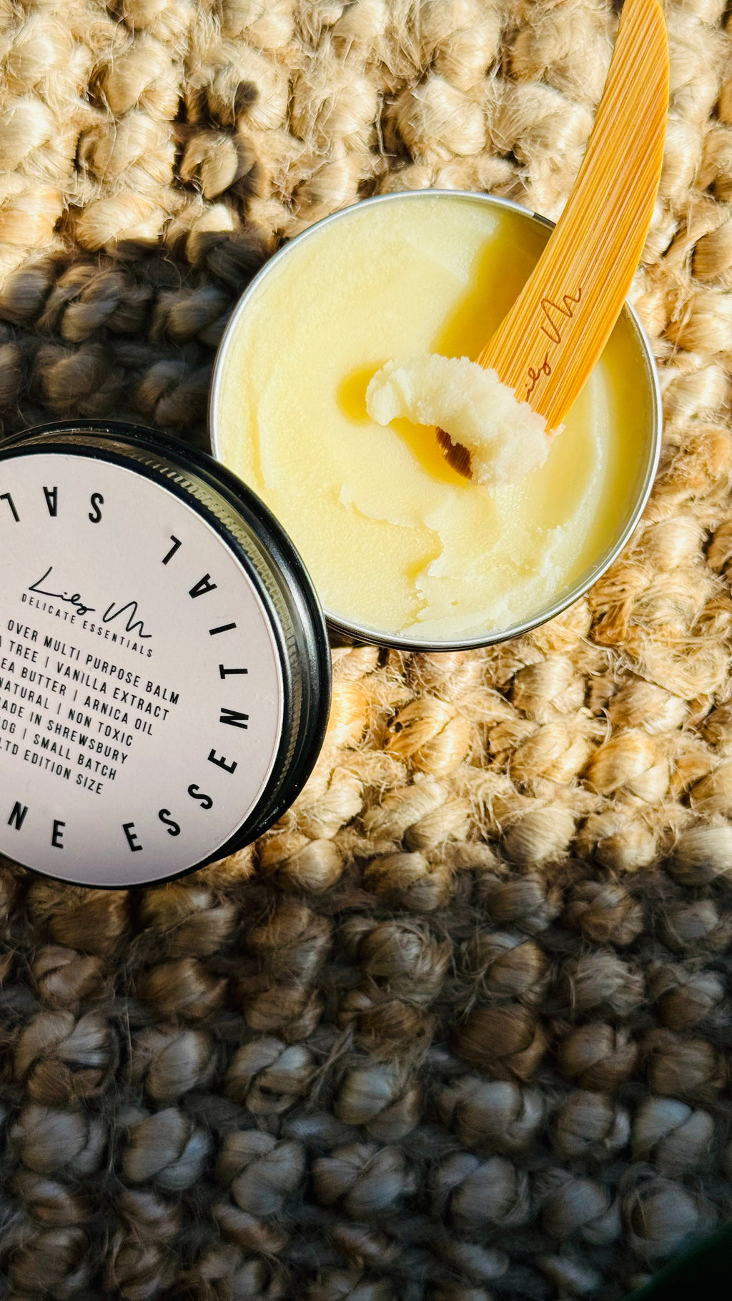 multi purpose balm with lid off and a wooden Lily M spatula, showing the texture - image rotated slightly to see more of the lid