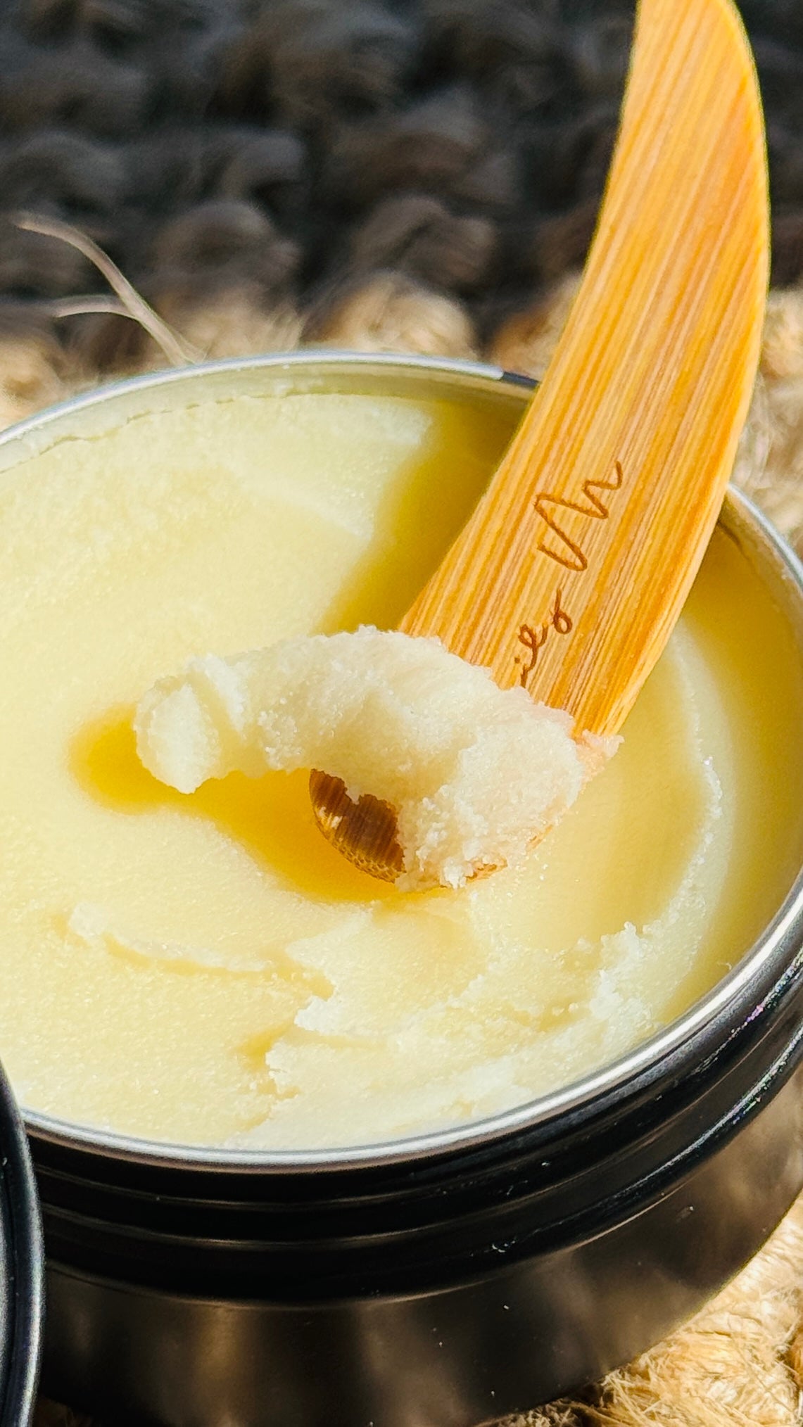 multi-purpose balm with the lid off and a wooden Lily M spatula, showing the texture - close-up image