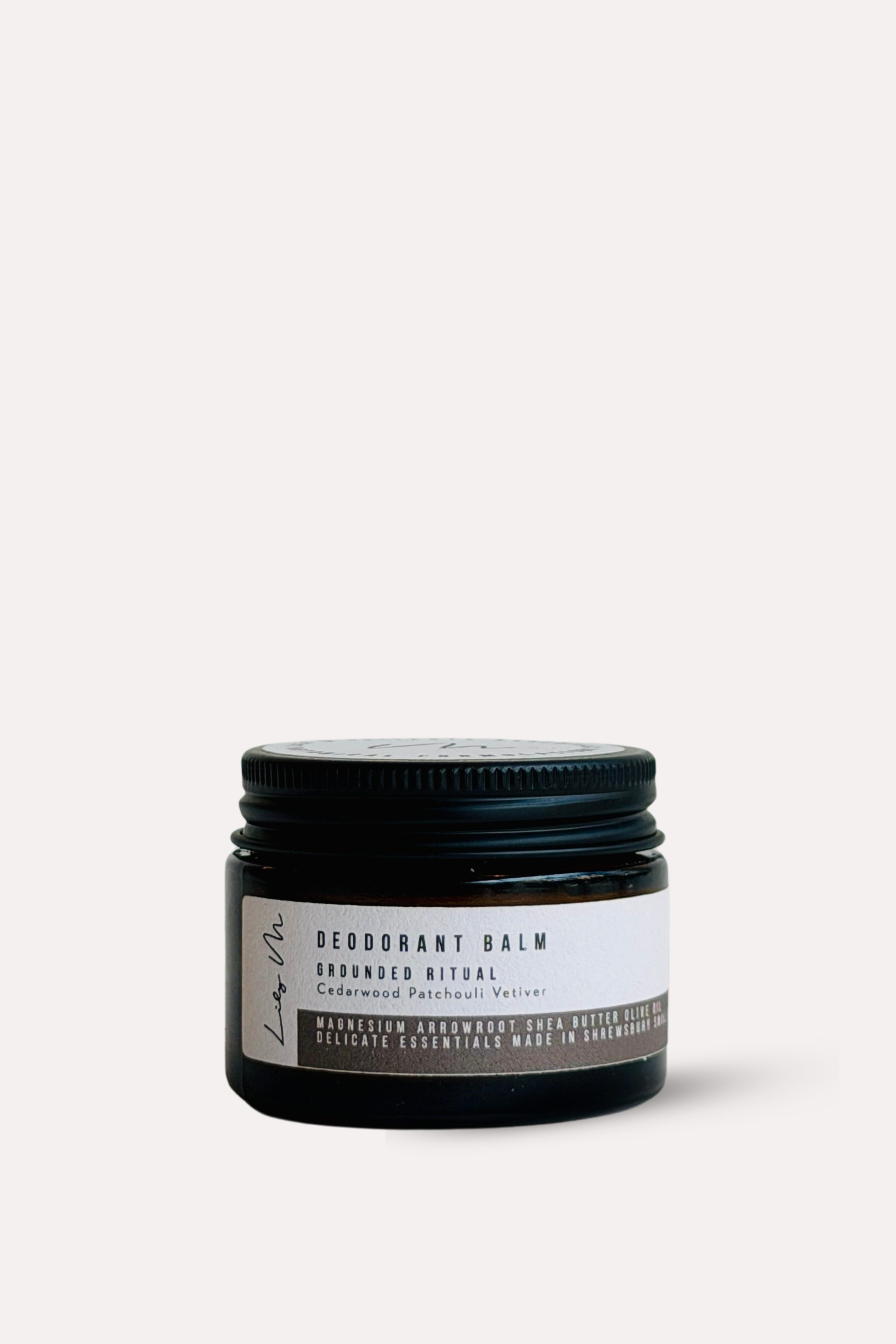 Deodorant balm jar with black lid on a white background